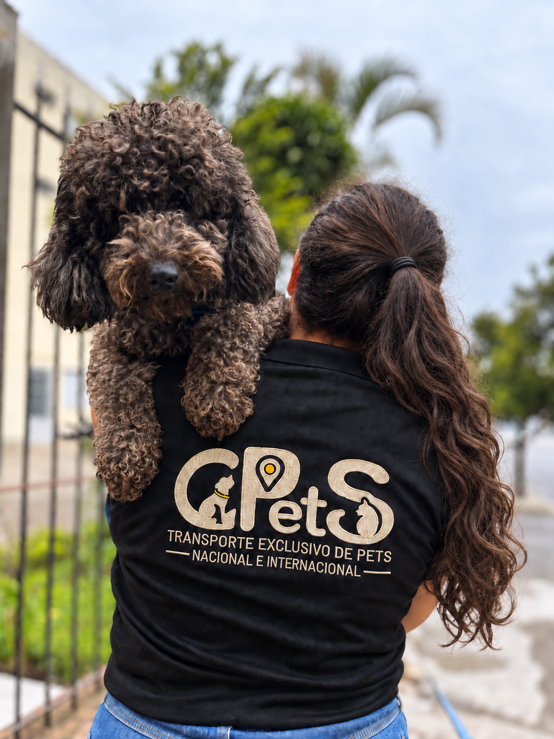 Colaboradora da Gpets com camiseta da marca segurando um cachorro no colo